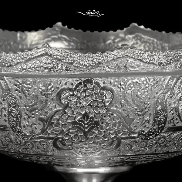 کاسه نقره گرد پایه دار قلم گل و مرغ هنر دست و ساخته شده از 729 گرم نقره عیار 84 درصد و قطر 21 و ارتفاع 22 سانتیمتر موجود در شعب نقره بخشی.