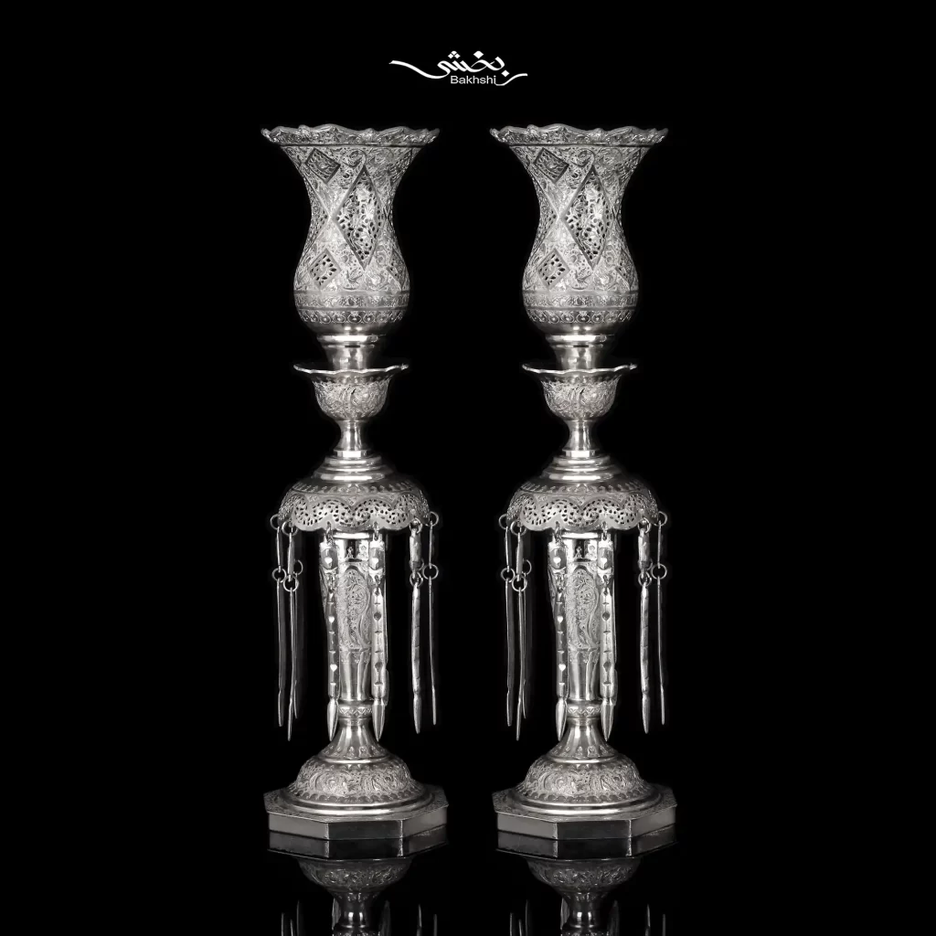 ست آینه تاجدار و شمعدان لاله آویزدار نقره اسلیمی و آینه با ابعاد 82*47 و شمعدان با ارتفاع 50 سانتیمتر و ساخته شده از نقره با عیار 84 موجود در نقره بخشی.