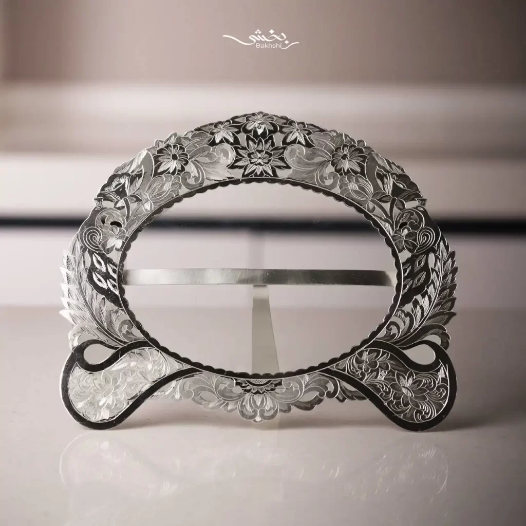 قاب عکس نقره بیضی قلم تبریز ساخته شده از 125.3 گرم نقره با عیار 84 درصد و ابعاد بیرونی 19 در 16 سانتیمتر موجود در شعب حضوری و سایت نقره بخشی.