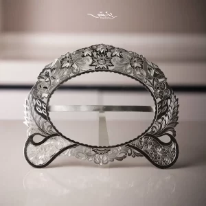 قاب عکس نقره بیضی قلم تبریز ساخته شده از 125.3 گرم نقره با عیار 84 درصد و ابعاد بیرونی 19 در 16 سانتیمتر موجود در شعب حضوری و سایت نقره بخشی.