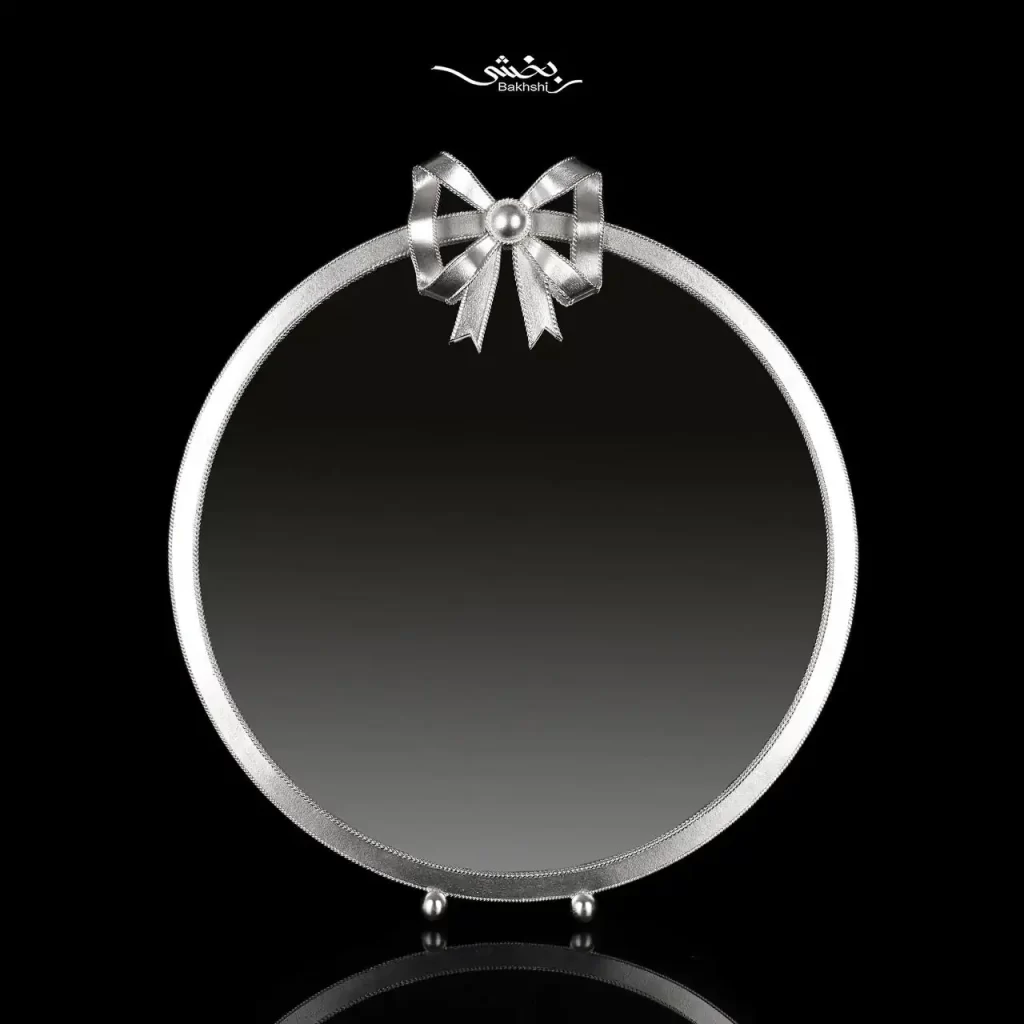 آینه گرد نقره پاپیون با ابعاد 35 در 31 سانتیمتر و وزن 187 گرم نقره با عیار 999 موجود در شعب حضوری و وبسایت رسمی نقره بخشی.