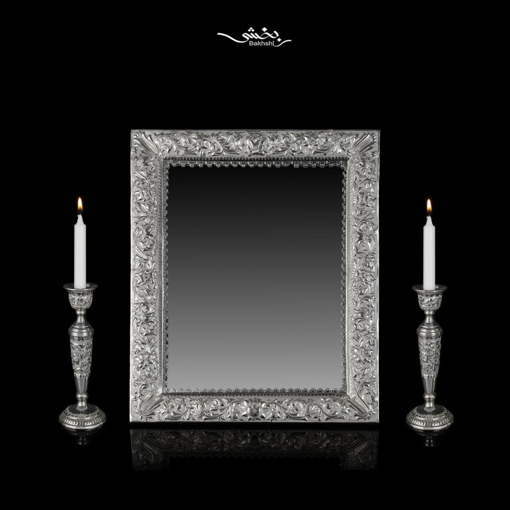 ست آینه مستطیل و شمعدان نقره تک شاخه گل برجسته ساخته شده از 1402 گرم نقره با عیار 84 درصد موجود در فروشگاه و سایت نقره بخشی.