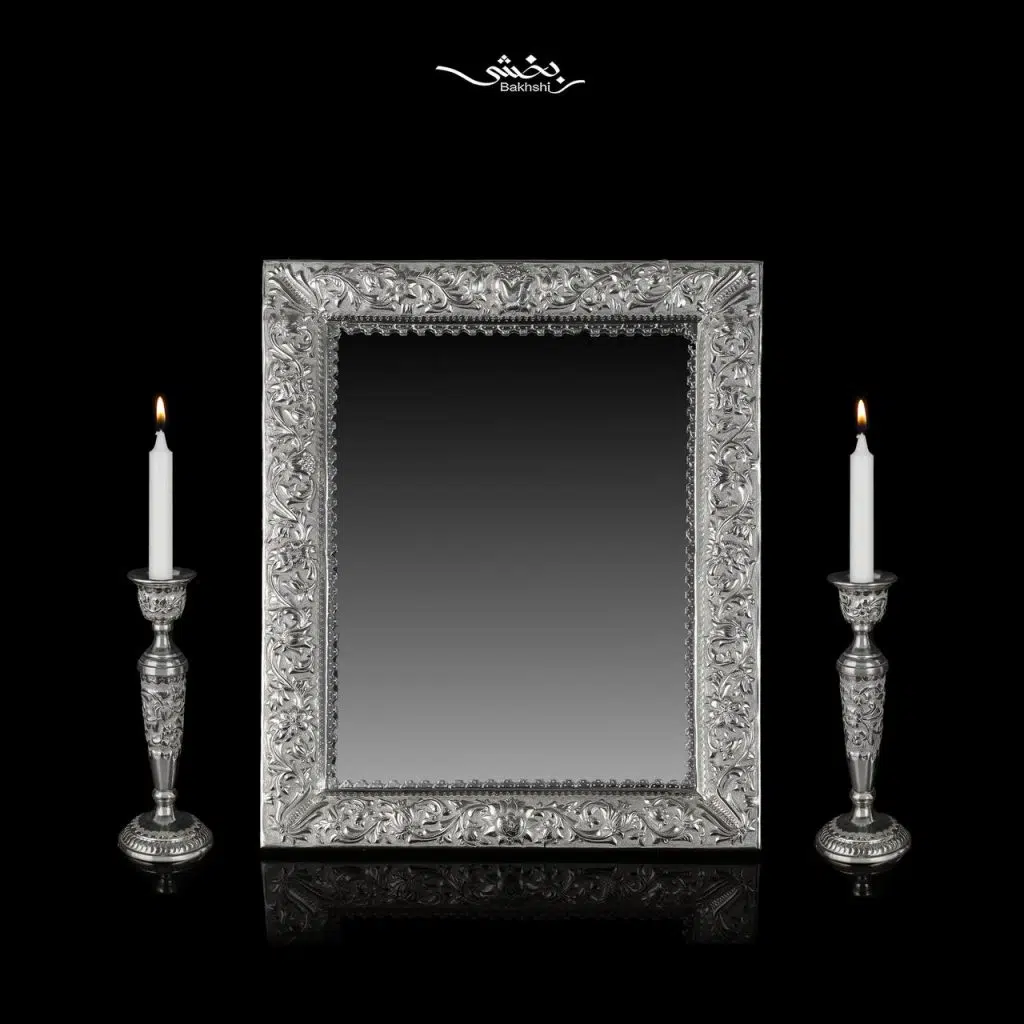 ست آینه مستطیل و شمعدان نقره تک شاخه گل برجسته ساخته شده از 1402 گرم نقره با عیار 84 درصد موجود در فروشگاه و سایت نقره بخشی.